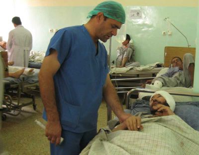 Doctor with a bomb victim in a Kabul hospital.