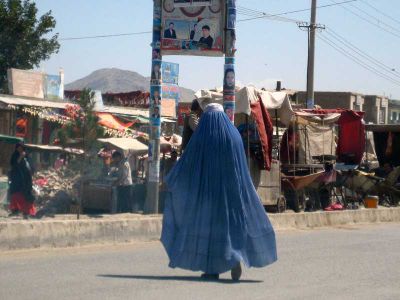 Woman in burqa crossing an Afghan street.