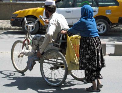 A disabled Afghan man in makeshift wheelchair.