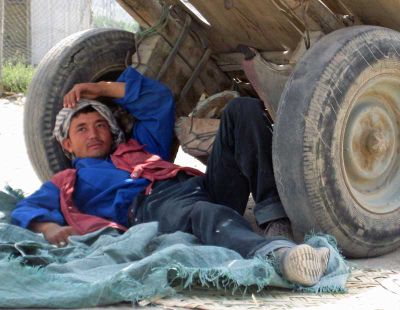 A laborer takes a break in the shade.