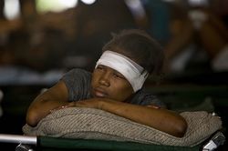 A Haitian girl rests after receiving treatment at an ad hoc medical clinic in the aftermath of the Haitian earthquake.