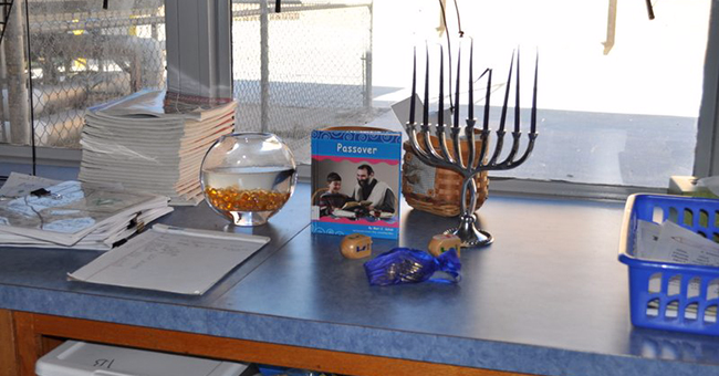A Hanukkah menorah, dreidel, Hanukkah gelt, and children's book on Passover on display during a world religions unit on Judaism, Wichita, KS.
