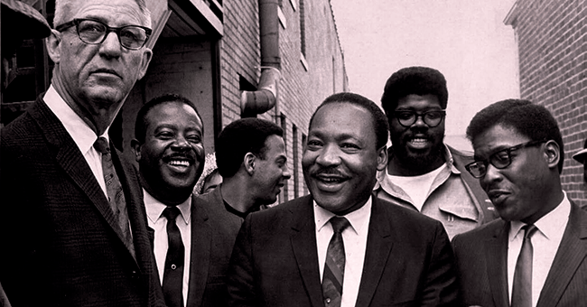 As US Marshal Cato Ellis serves an injunction on MLK, King and his aides (l to r), Ralph Abernathy, Andrew Young, James Orange and Bernard Lee, share a laugh to lighten the mood.