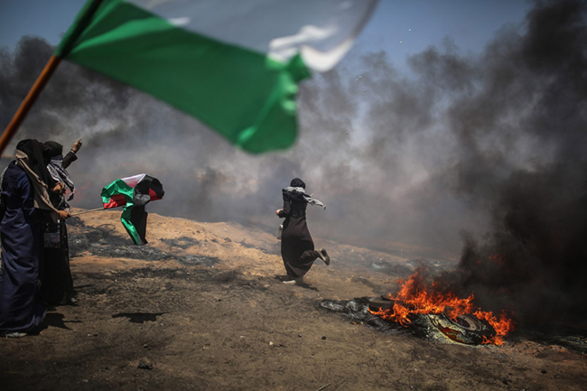 A Palestinian throws a rock in response to Israel's intervention during a protest, organized to mark 70th anniversary of Nakba - Jordi Bernabeu Farrus - Flikr