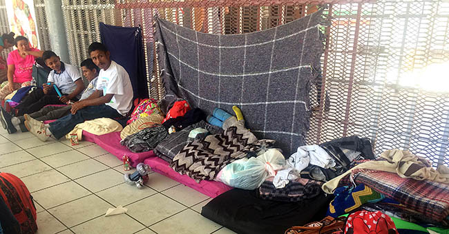 Asylum seekers waiting in line  sitting on blankets donated by local people in Nogales  Sonora. They're waiting to make their case with a U.S. immigration agent.