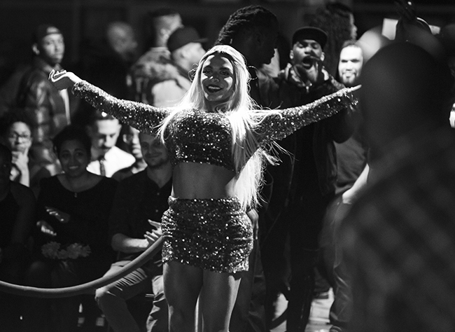 A young woman basking in the spotlight. Red Ball, Brooklyn Expo Center, 2019. © John Emrys Eller.