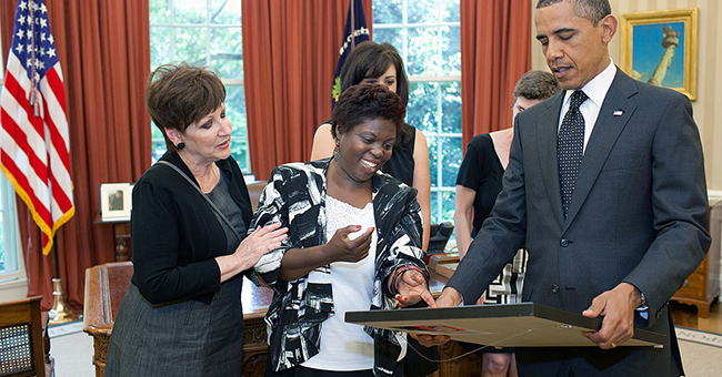 Lois Curtis, plaintiff in the “Olmstead v. L.C.” SCOTUS case, (center) presents President Barack Obama with a self-portrait of herself as a child.